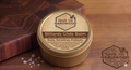 Hive to Hardwood Billiards Glide Balm container on a wooden surface