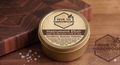 Jar of 'Hive to Hardwood' Instrument Elixir on a wooden surface
